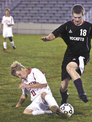 Austin's Howie Underwood kicks the ball from Rochester John Marshall's Taylor Kloss during the first half Thursday night at Art Hass Stadium